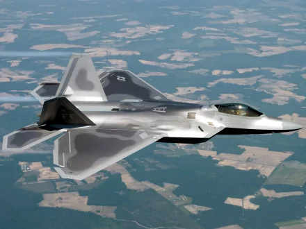 A Lockheed Martin F-22 Raptor flying over a landscape, featured in a high-definition wallpaper and background image tagged with military.