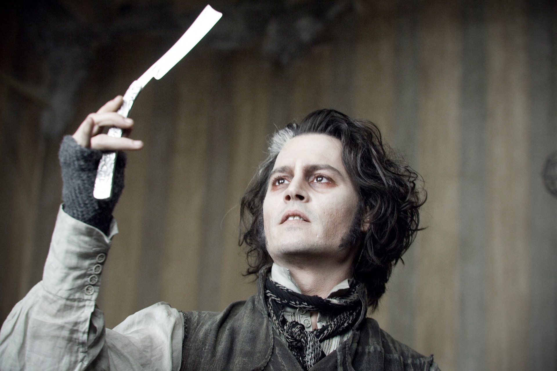 Johnny Depp as Sweeney Todd holds a razor in a dramatic scene from *Sweeney Todd: The Demon Barber of Fleet Street in Concert*. HD wallpaper featuring the film's dark atmosphere.
