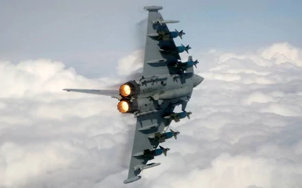 HD wallpaper of a Eurofighter Typhoon jet in flight with afterburners lit, soaring above the clouds. A powerful image highlighting military aviation.