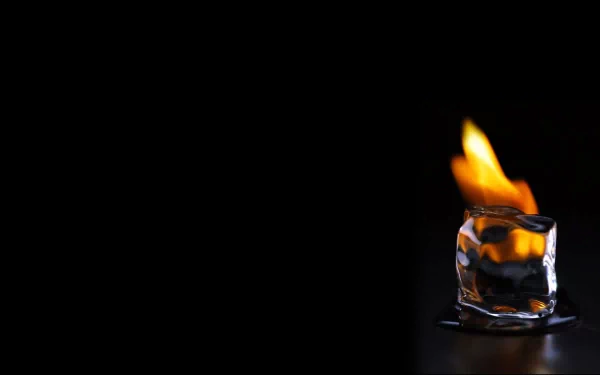 HD desktop wallpaper featuring an artistic and elemental theme, showing a burning ice cube against a black background.