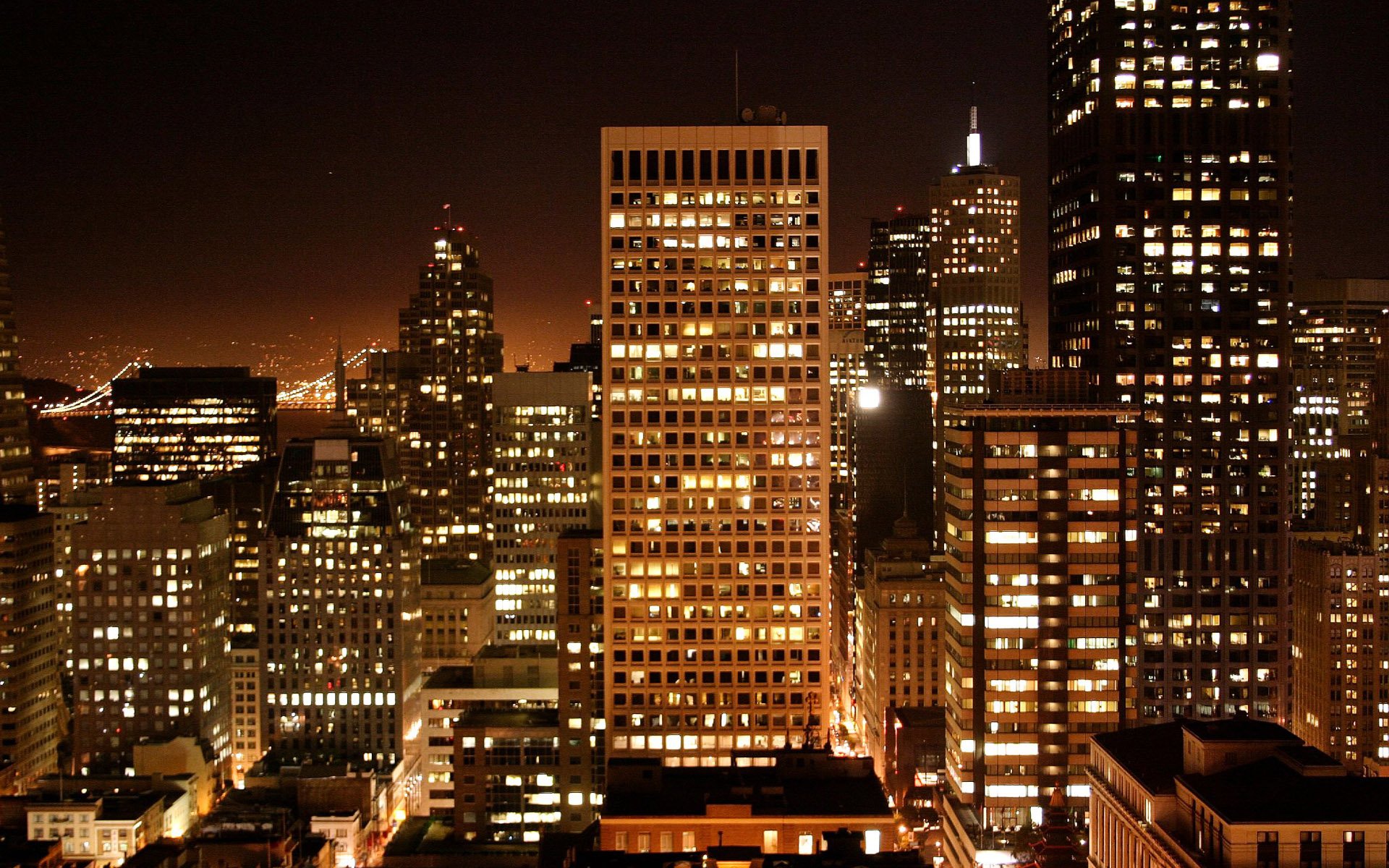 Nighttime view of illuminated San Francisco skyscrapers, showcasing the city's vibrant urban skyline in this HD man-made desktop wallpaper.