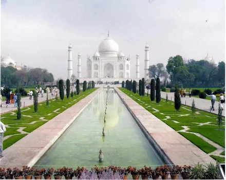 HD desktop wallpaper of the Taj Mahal, featuring its iconic white marble mausoleum, reflecting pool, and surrounding greenery, showcasing the architectural splendor of this man-made wonder.
