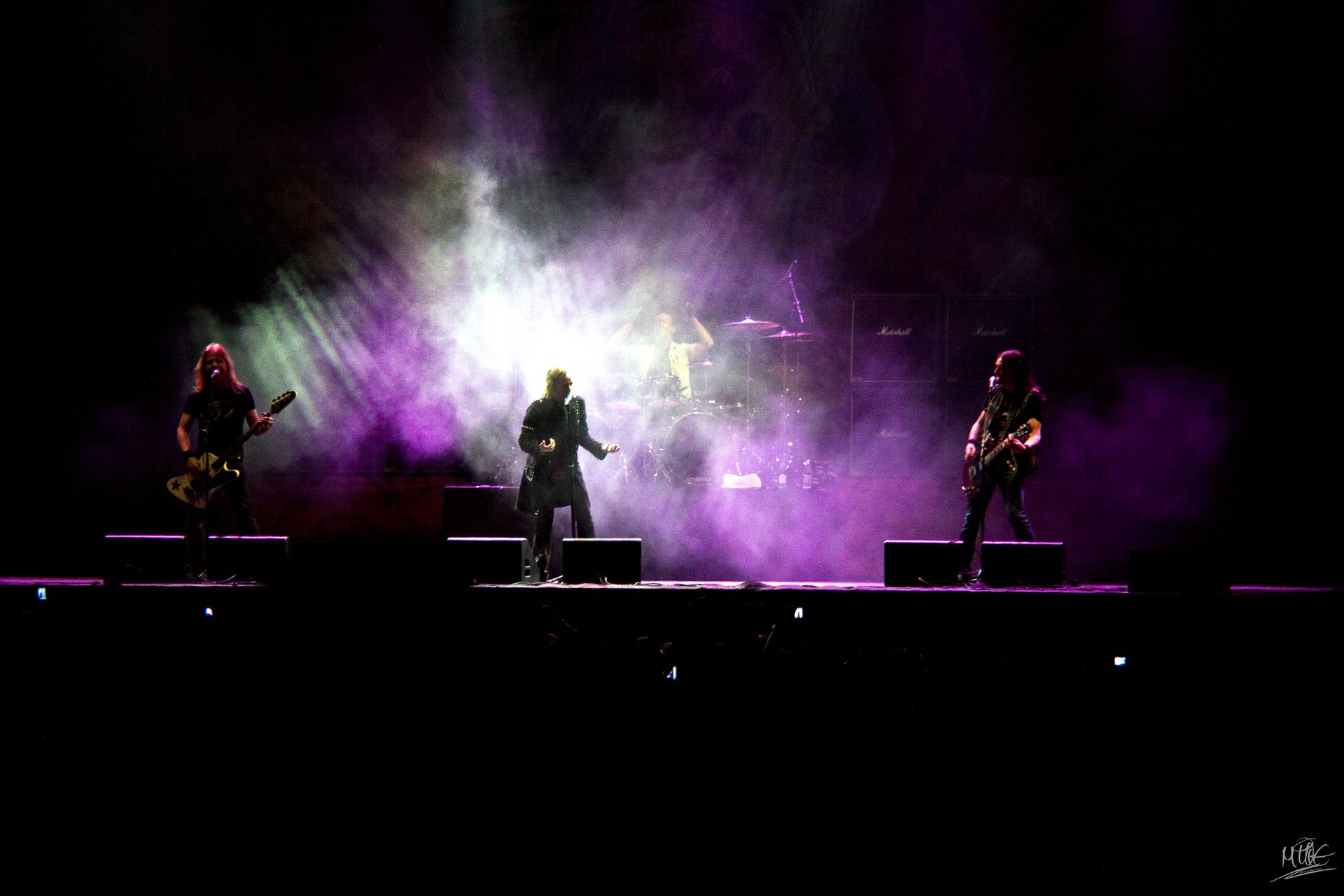 HD PC desktop wallpaper featuring the band Edguy performing live on stage with vibrant purple and white stage lighting and smoke effects.