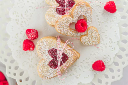 HD PC desktop wallpaper featuring heart-shaped cookies with raspberry jam, powdered sugar, and fresh raspberries on a delicate lace doily, tagged food and cookie.