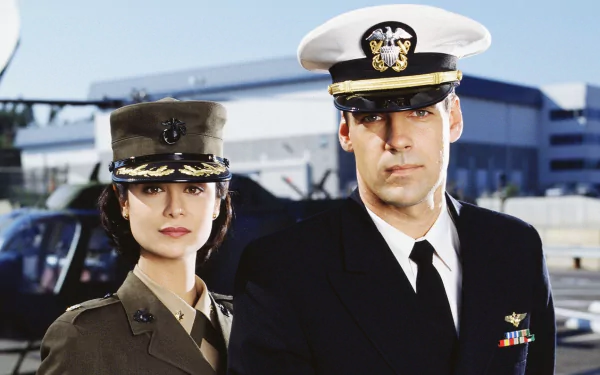 HD PC desktop wallpaper featuring two characters from the TV show JAG dressed in military uniforms with a helicopter and hangar in the background.