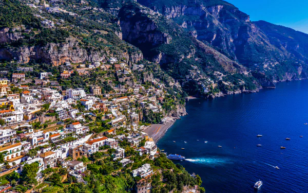 A vibrant HD wallpaper showcasing Positano’s colorful hillside buildings, lush greenery, and serene blue waters, capturing the essence of this stunning coastal town.
