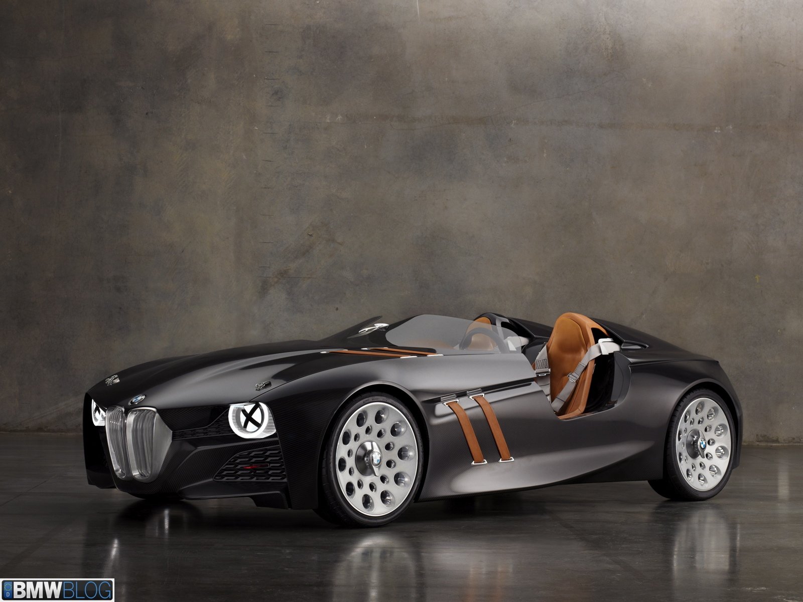 HD PC desktop wallpaper featuring a sleek black BMW convertible vehicle with brown interior, set against a minimalistic gray background.