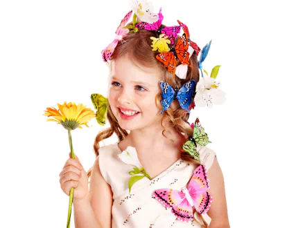 A cheerful child with curly hair adorned with colorful butterflies and flowers, holding a yellow flower, set against a white backdrop. Photography HD desktop wallpaper and background.