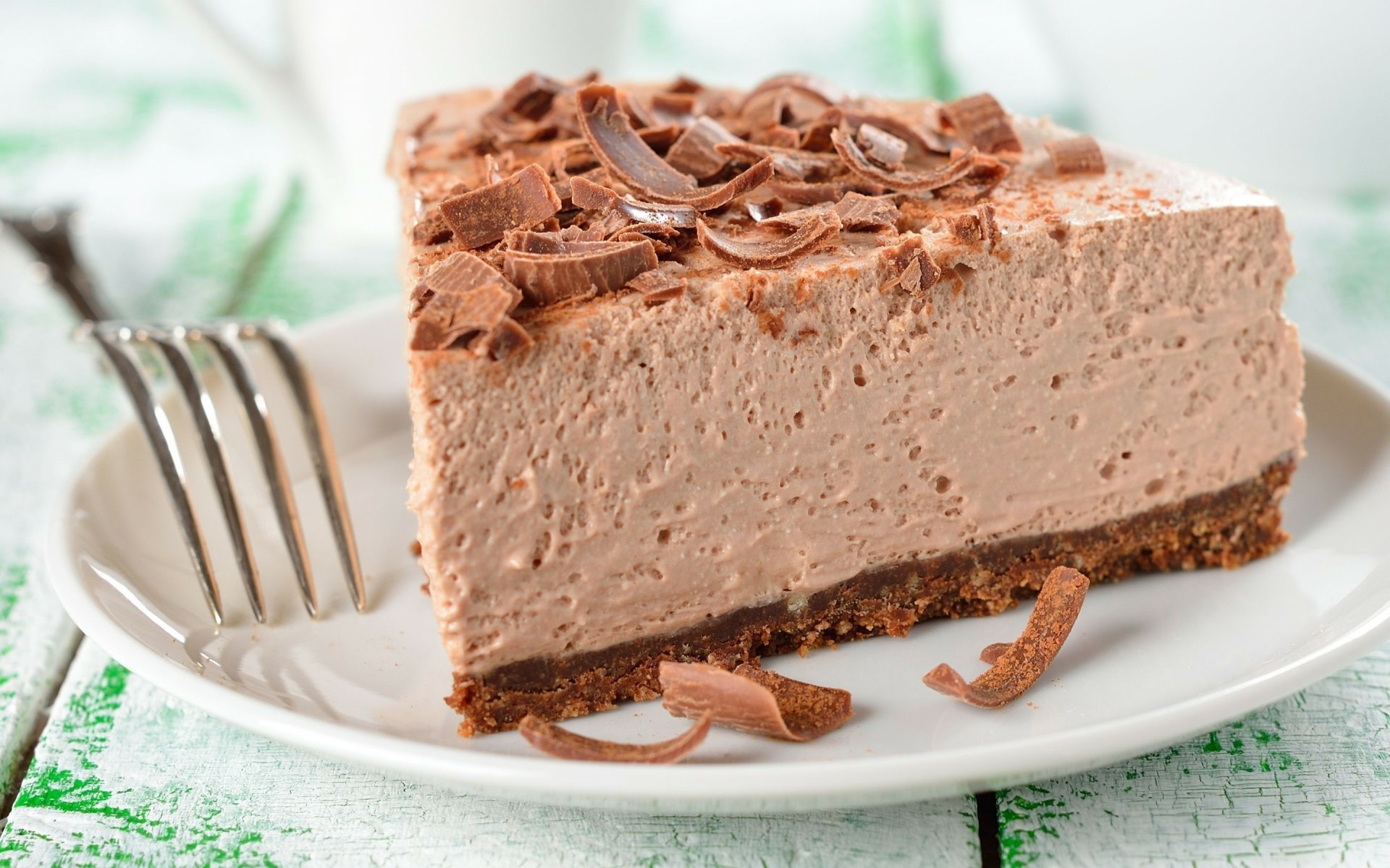 HD desktop wallpaper and background featuring a slice of rich chocolate mousse cake with chocolate shavings, presented elegantly on a white plate.