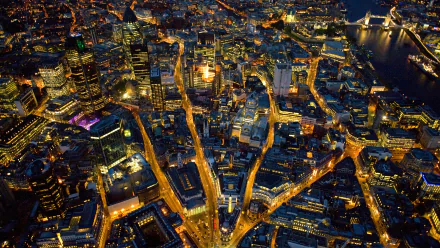 A stunning HD wallpaper of London's vibrant skyline at night, showcasing intricate city streets illuminated by city lights. A captivating man-made landscape.