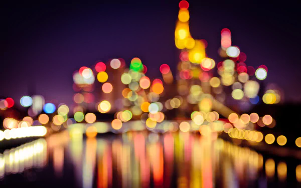 A vibrant bokeh depiction of a city skyline at night, with colorful lights reflecting on the water, creating an artistic and dreamlike atmosphere for a HD desktop wallpaper.