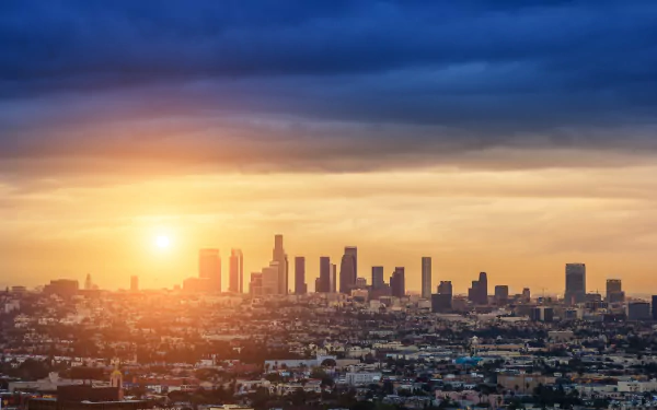 A stunning HD wallpaper showcasing the Los Angeles skyline at sunset, with vibrant colors illuminating the city's iconic buildings against a dramatic sky.