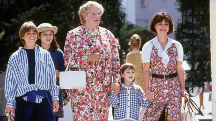 A vibrant HD wallpaper from the movie Mrs. Doubtfire, featuring a cheerful Robin Williams in disguise, surrounded by a group of children and an adult woman, capturing a lighthearted moment.