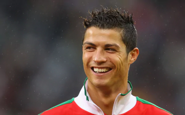 HD desktop wallpaper featuring a smiling Cristiano Ronaldo in a green and red sports kit.