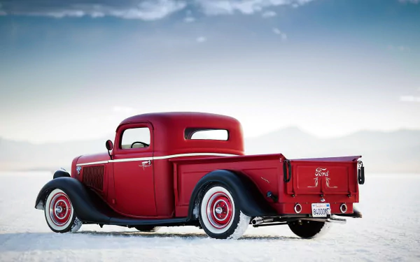 HD PC desktop wallpaper background of a red Ford Deluxe Pickup vehicle resting on a white salt flat beneath a pale sky.
