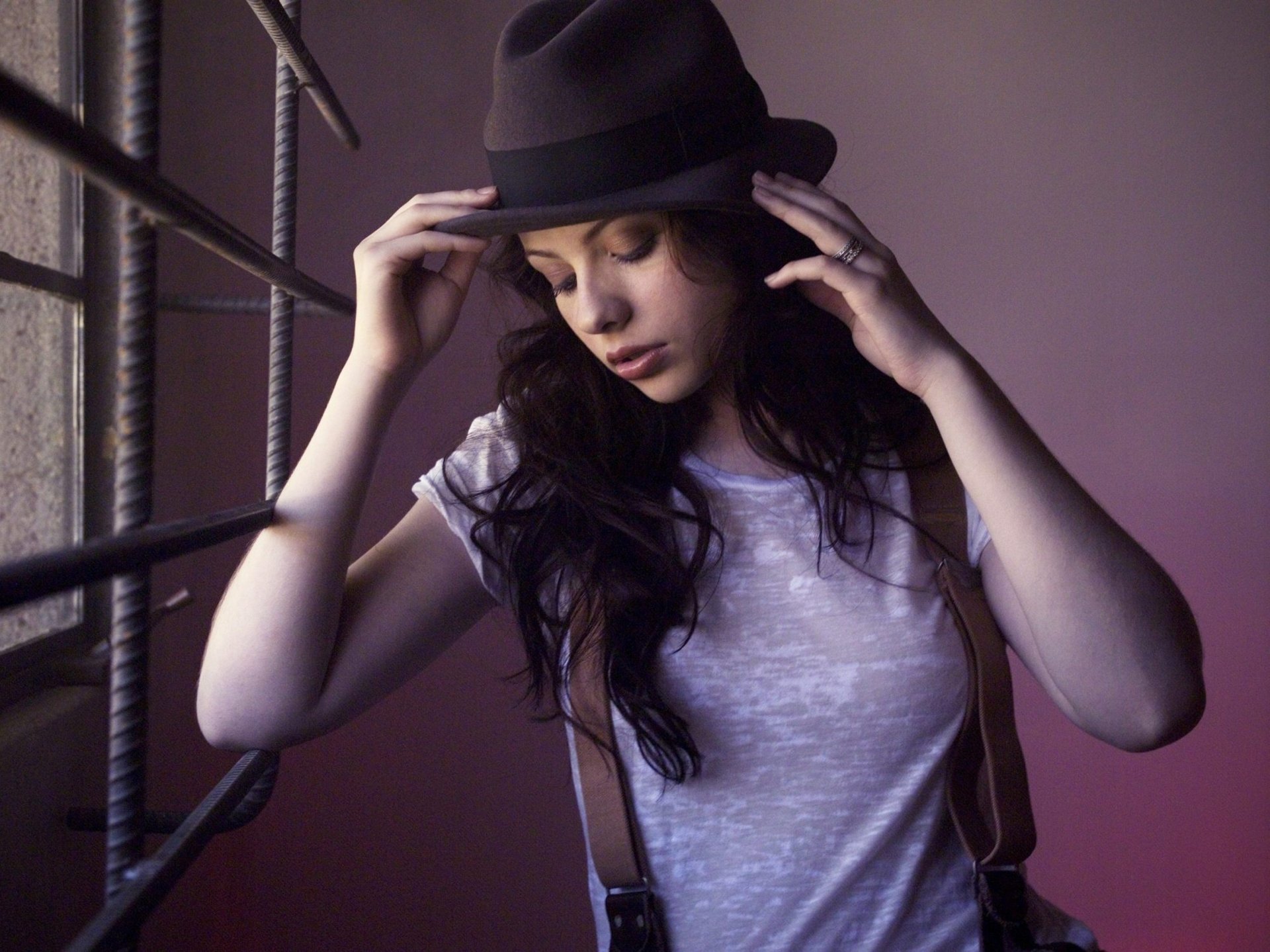 A 4K Ultra HD PC desktop wallpaper featuring celebrity Michelle Trachtenberg wearing a black hat and white shirt, posing thoughtfully near a window with soft lighting.
