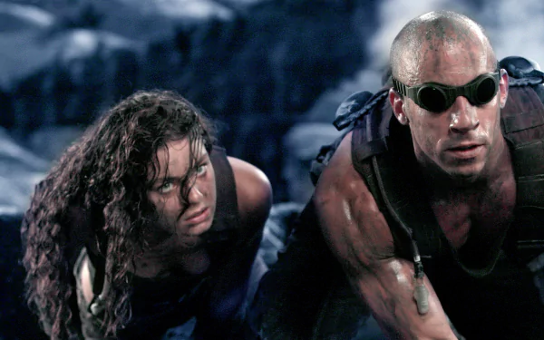 2K Quad HD PC desktop wallpaper: gritty scene from the movie The Chronicles of Riddick with two battle-worn characters crawling across rocky terrain.