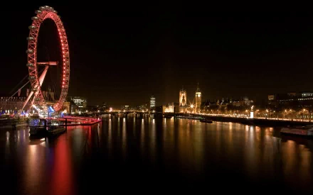 Night view of the illuminated London Eye and cityscape reflecting on the River Thames, captured in a high-definition desktop wallpaper from London.