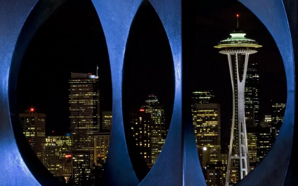 Nighttime view of Seattle’s skyline featuring the illuminated Space Needle framed by man-made architectural elements, captured as an HD PC desktop wallpaper.