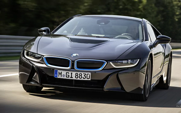 HD PC desktop wallpaper featuring a sleek black BMW i8 sports car driving on a road surrounded by greenery.