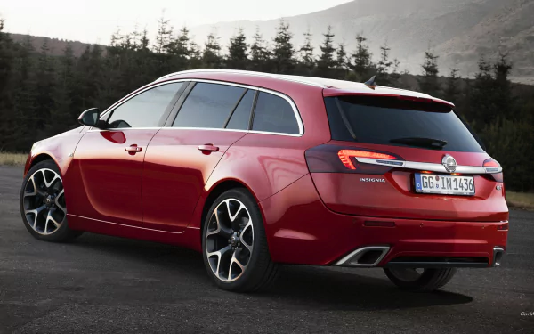Red 2014 Opel Insignia OPC Sports Tourer parked on a mountain road with fir trees and misty hills, rendered as an HD PC desktop wallpaper/background.
