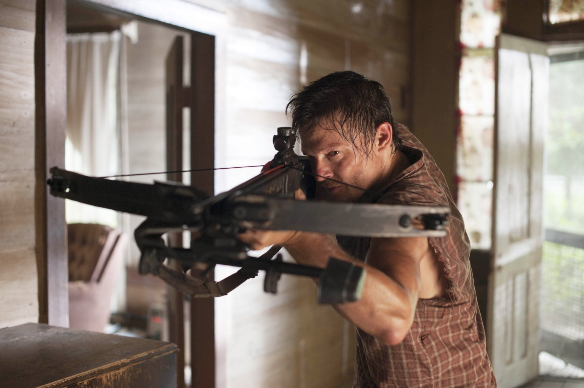 Daryl Dixon, portrayed by Norman Reedus in The Walking Dead, takes aim with a crossbow in this intense HD desktop wallpaper, capturing the essence of the thrilling TV show.
