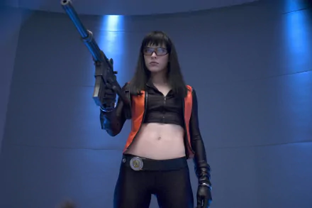 HD PC desktop wallpaper featuring a character from the movie Ultraviolet, holding a futuristic weapon in a sleek, sci-fi setting with blue lighting.