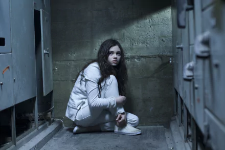 Crouching woman in a white jacket in a dim concrete locker room — scene from the movie Underworld: Awakening; 2K Quad HD PC desktop wallpaper/background.