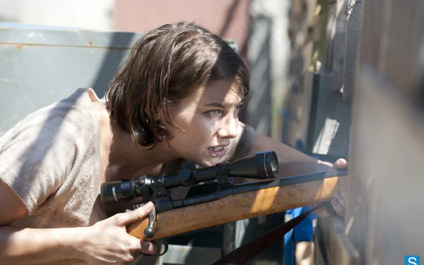 Maggie Greene, portrayed by Lauren Cohan, takes aim with a rifle in this intense scene from the TV show The Walking Dead, capturing a moment of suspense in high-definition wallpaper.