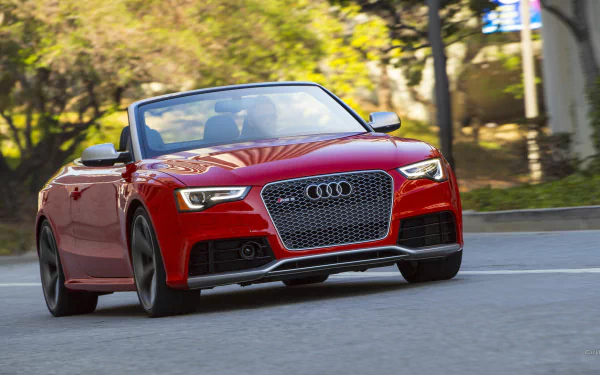 Red Audi RS5 convertible driving on a sunlit, tree-lined street — HD PC desktop wallpaper/background.