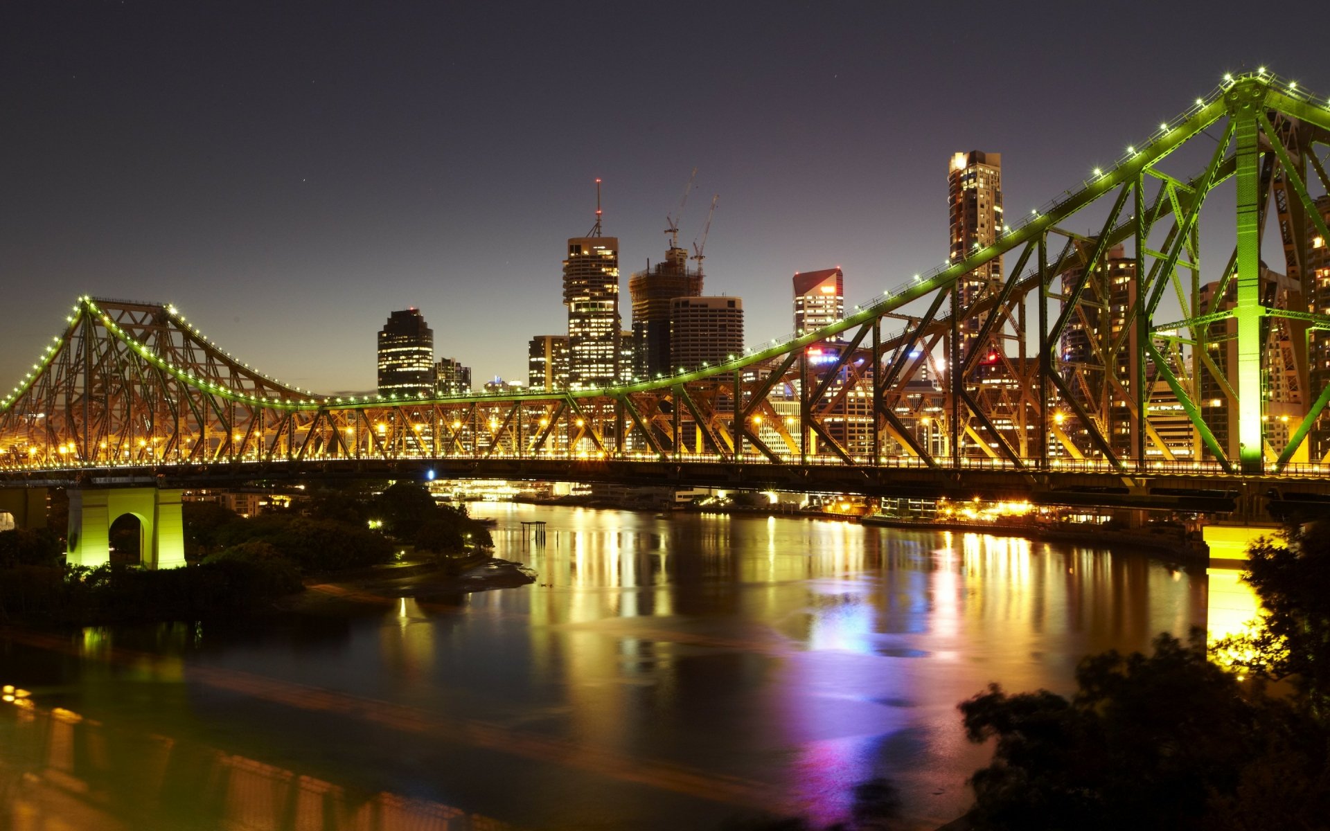 Night view of Brisbane's illuminated Story Bridge spanning the river with skyline reflections — man-made landmark, Australia; 2K Quad HD PC desktop wallpaper/background.