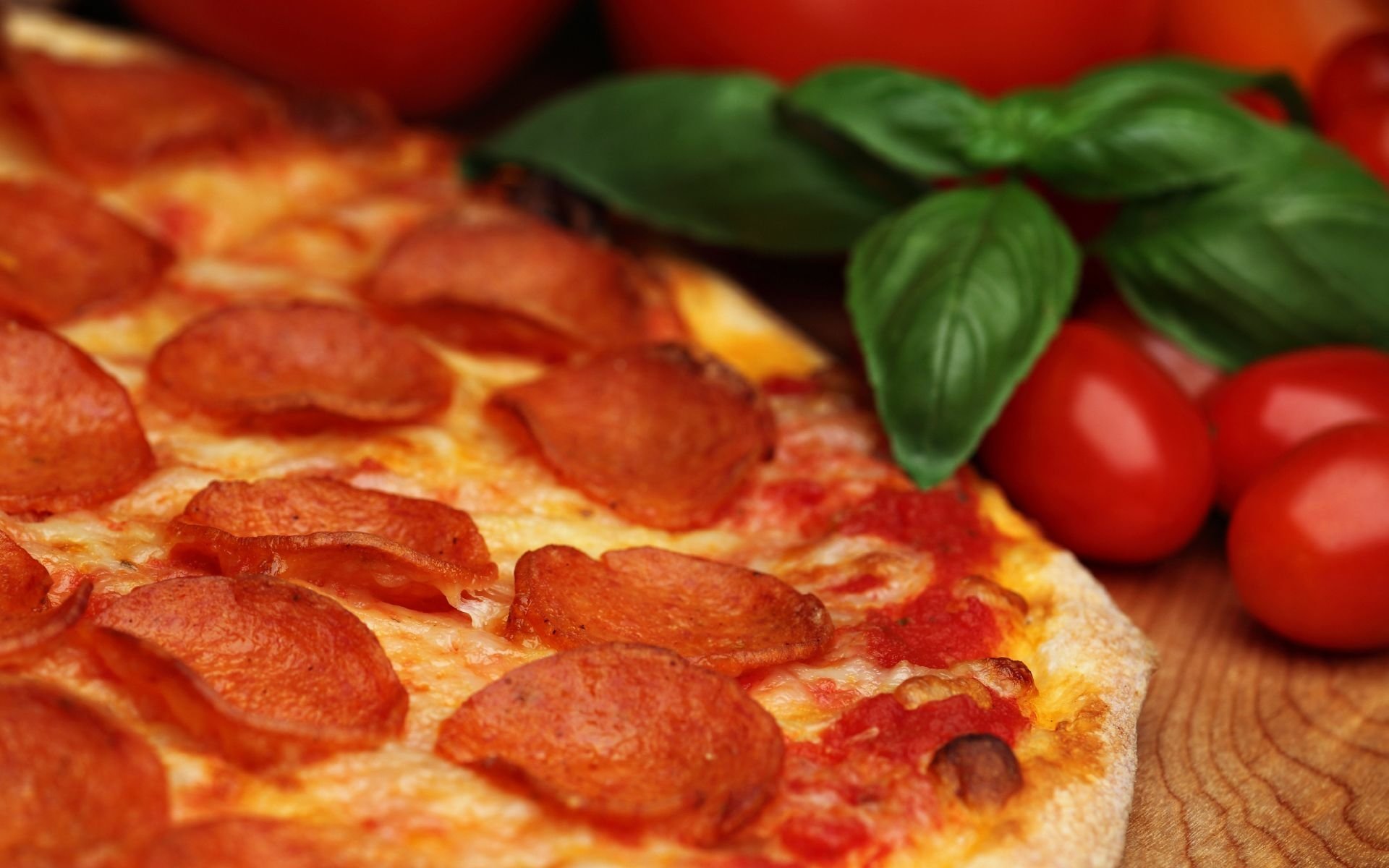 HD PC desktop wallpaper and background: close-up pepperoni pizza with melted cheese, fresh basil and cherry tomatoes on a wooden board.