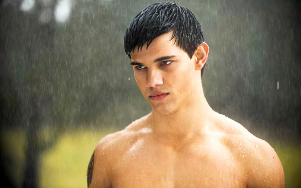 A striking 4K Ultra HD desktop wallpaper featuring Taylor Lautner, showcasing him with a serious expression as rain pours around him, highlighting his dynamic presence.