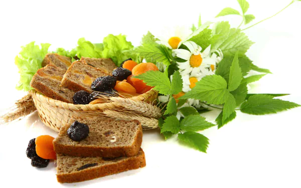 4K Ultra HD PC desktop wallpaper of rustic bread and dried fruits in a wicker basket, surrounded by greens and chamomile on a white background.