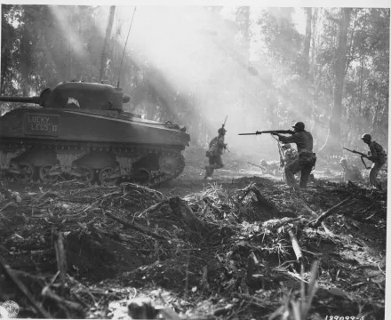 Black-and-white military scene with an M4 Sherman tank and infantry advancing through a misty, debris-strewn forest — HD PC desktop wallpaper/background.