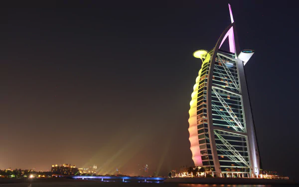 A stunning 4K Ultra HD image of the Burj Al Arab, showcasing its iconic sail-shaped architecture illuminated at night against the Dubai skyline.