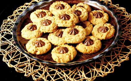 A beautifully arranged platter of cookies, featuring a rich chocolate center, set on an intricate woven mat. This HD image serves as an inviting desktop wallpaper.