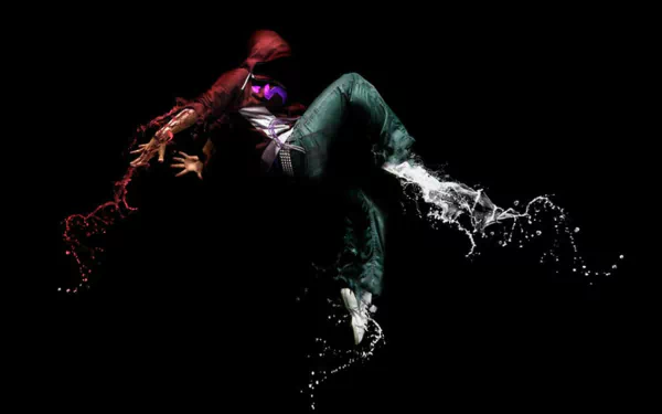 A vibrant HD desktop wallpaper featuring a dancer in motion, surrounded by splashes of color and water, embodying the energy of music and dance against a dark background.