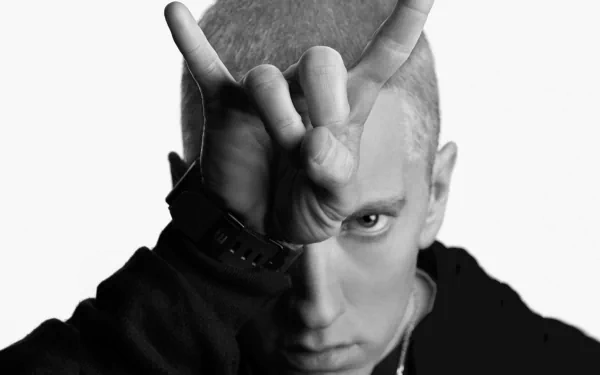 Black and white HD desktop wallpaper featuring Eminem making a hand gesture, embodying his music's intensity and style. A striking background for any fan of hip-hop.
