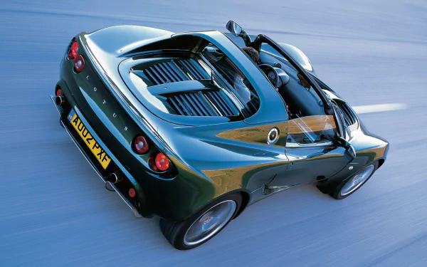 HD desktop wallpaper featuring a sleek black Lotus Elise sports car in motion, showcasing its aerodynamic design and distinctive rear details.
