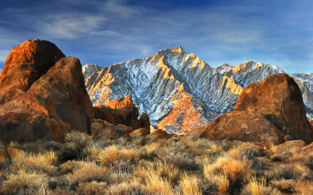HD wallpaper showcasing California's Sierra Nevada mountains with Alabama Hills' rocky foreground and Lone Pine Peak illuminated by golden sunlight under a clear blue sky.