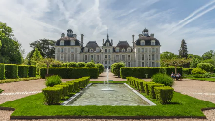HD desktop wallpaper featuring the symmetrical facade of Château de Cheverny with manicured gardens and a rectangular pond in the foreground.
