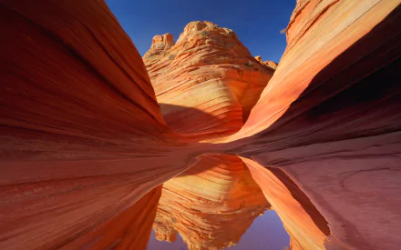 HD PC desktop wallpaper showcasing the vivid, swirling rock formations and deep crevices of Antelope Canyon under a clear blue sky.