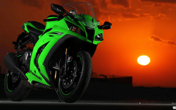 A vivid HD PC desktop wallpaper featuring a bright green Kawasaki Ninja ZX-10R motorcycle against a dramatic orange sunset sky.