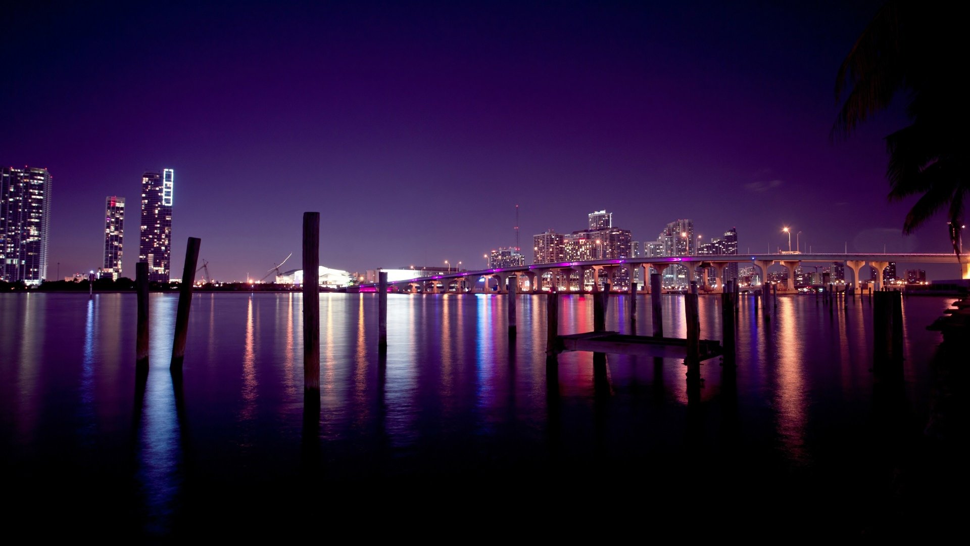Nighttime view of Miami's man-made skyline in Florida, reflected on calm waters, captured in stunning 4K Ultra HD resolution.