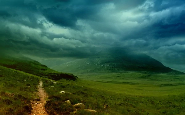 HD desktop wallpaper of a serene nature landscape featuring a path winding through lush green hills under a dramatic cloudy sky. The image conveys a peaceful and captivating ambiance.