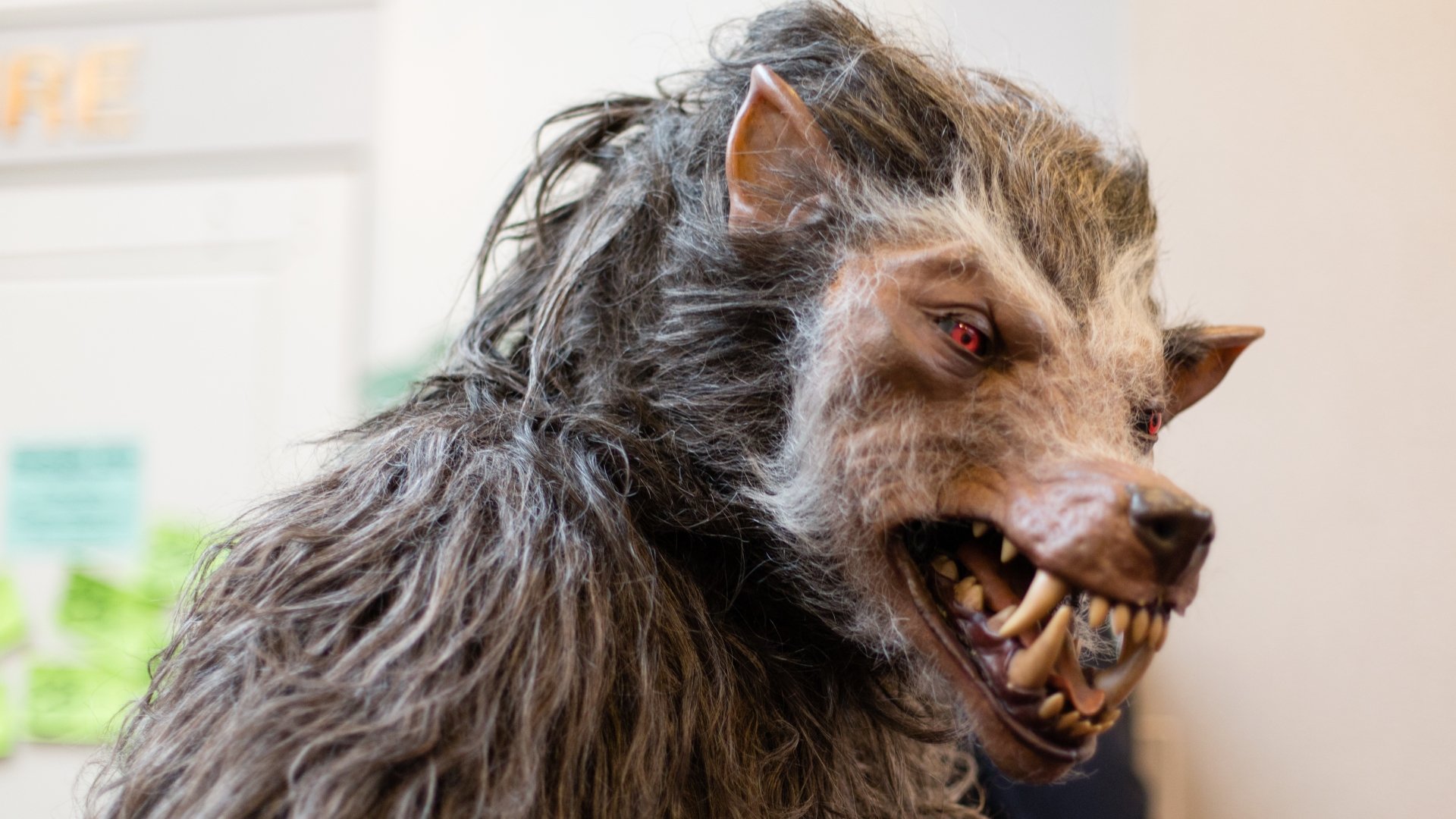 Close-up of a dark werewolf with sharp teeth and red eyes, rendered in 4K Ultra HD for a striking PC desktop wallpaper and background.