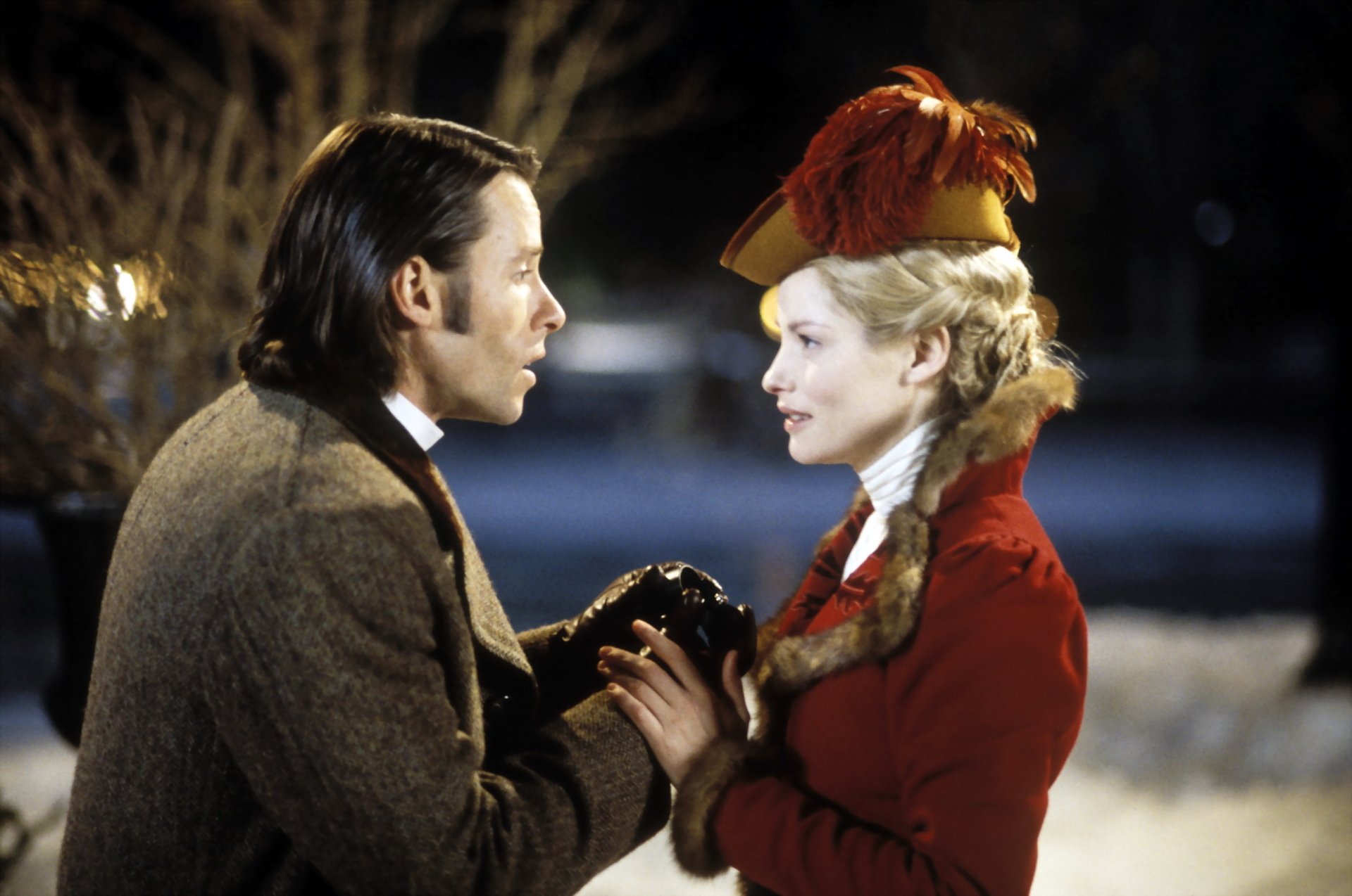 The Time Machine (2002) still — man and woman in period costumes clasp hands in a snowy nighttime close-up; 2K Quad HD PC desktop wallpaper and background.