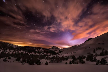 HD PC desktop wallpaper showing a dramatic night sky with stars and clouds over a snowy mountain landscape in nature.
