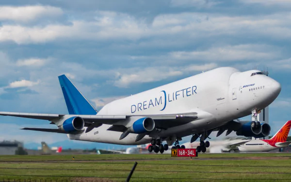 Boeing 747 Dreamlifter airplane taking off on runway under a cloudy sky, captured in high-definition wallpaper quality.